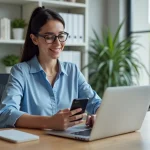 Femme au bureau moderne utilisant ordinateur et smartphone